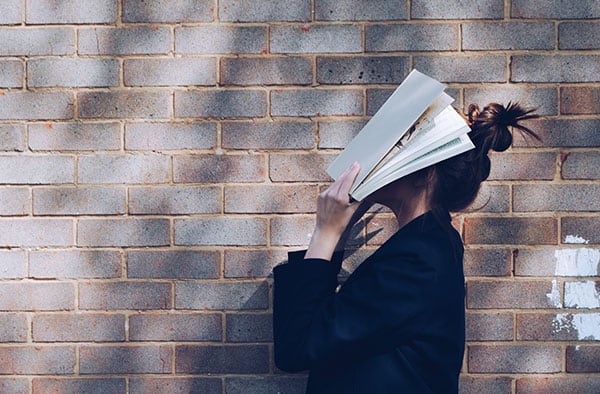 woman stressed out covering her face with a book